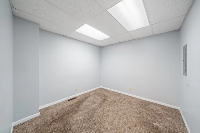a view of an empty room with wooden floor and closet