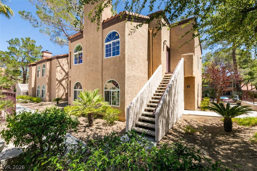 9325 West Desert Inn Road, Unit 244 Las Vegas, NV 89117 - Photo 1 of 55 A charming stucco exterior features arched windows and a tiled roof, set amongst mature landscaping.