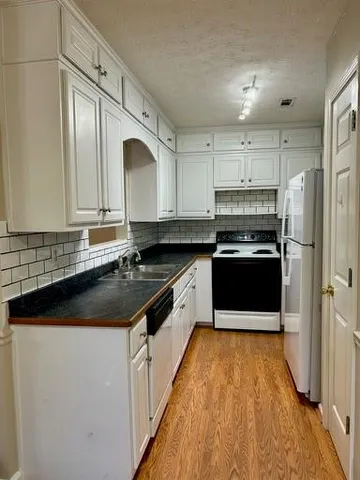 a kitchen with stainless steel appliances granite countertop a stove a sink and a refrigerator