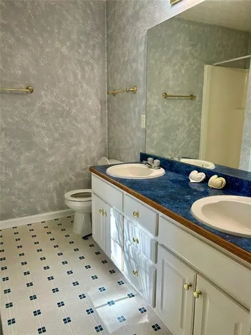 a bathroom with a sink a toilet and a mirror