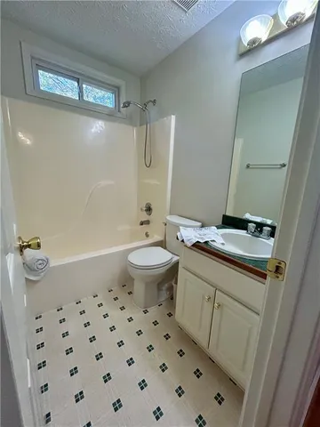 a bathroom with a granite countertop sink a toilet a mirror and shower