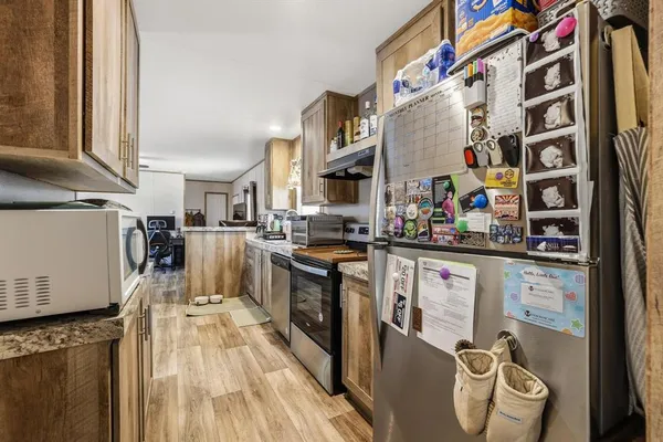 a kitchen with stainless steel appliances granite countertop a stove a sink and a refrigerator