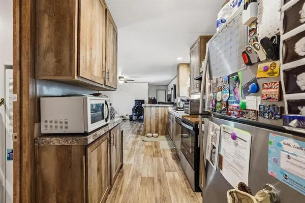 a kitchen with stainless steel appliances granite countertop a refrigerator a stove and a wooden cabinets