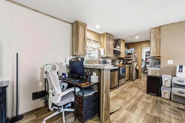 a kitchen with stainless steel appliances a stove top oven a sink a counter top space and cabinets