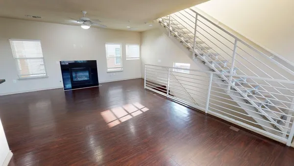 a view of a hallway with wooden floor and stairs