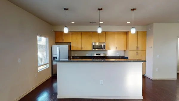 a kitchen with stainless steel appliances granite countertop a sink a refrigerator a stove a microwave and island