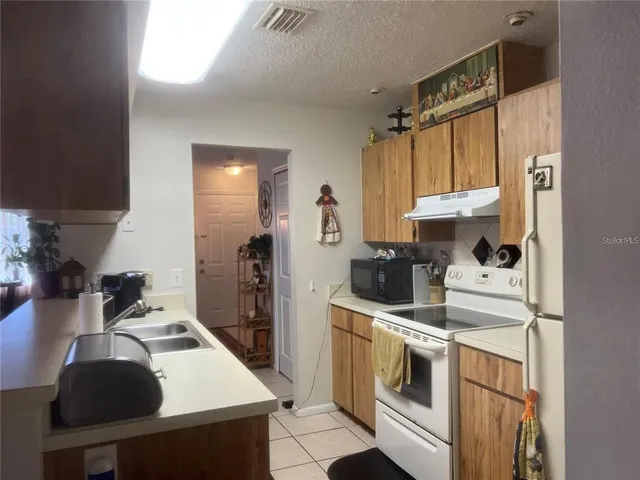 a kitchen with a sink stove and refrigerator