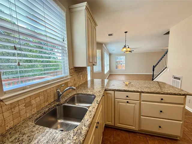 a kitchen with granite countertop a sink and a window