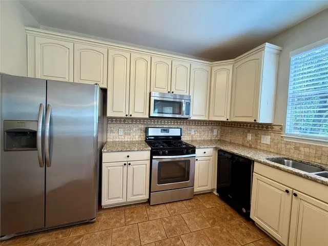 a kitchen with a sink stove and refrigerator