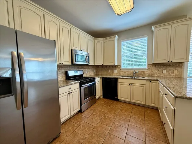 a kitchen with stainless steel appliances granite countertop a refrigerator sink and microwave