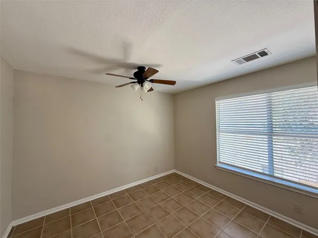 a view of a room with a window and a ceiling fan