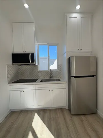 a kitchen with a refrigerator sink and cabinets