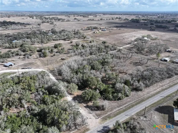 a view of a dry yard with wooden fence
