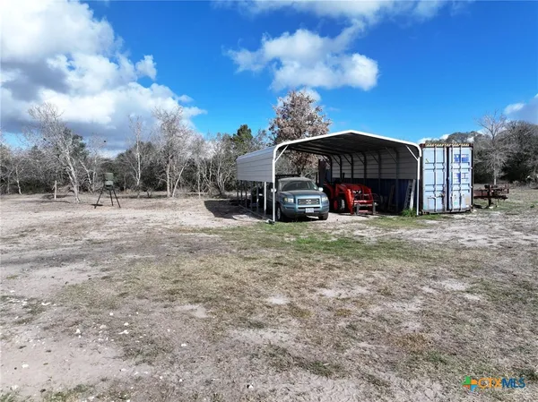 a view of dirt yard with a tree