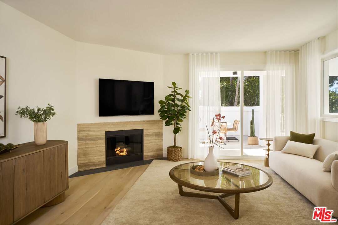 6487 Cavalleri Road, Unit 228 Malibu, CA 90265 - Photo 1 of 18 a living room with furniture a fireplace and a flat screen tv