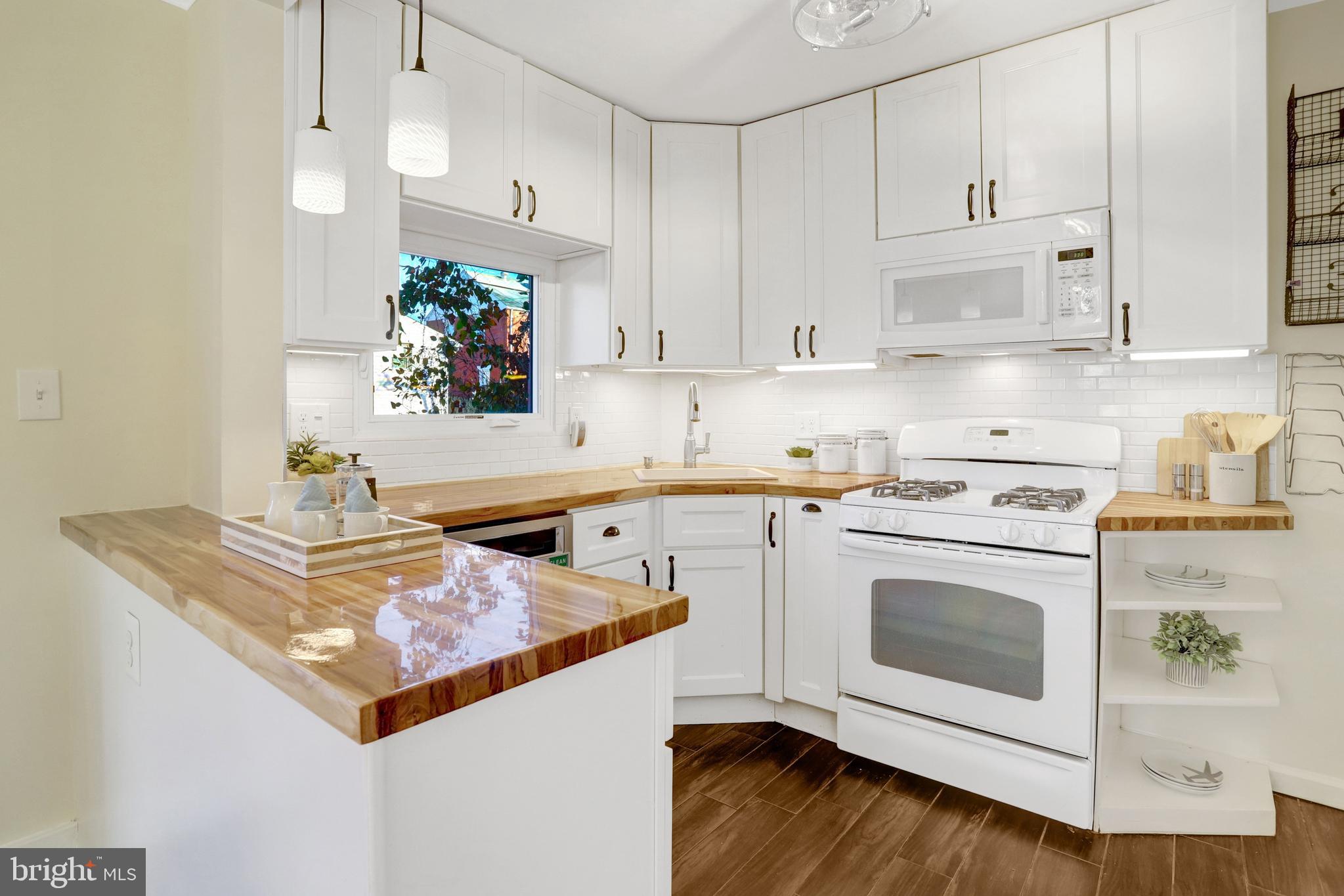 2137 South Pollard Street Arlington, VA 22204 - Photo 4 of 57 a kitchen with stainless steel appliances granite countertop a stove a sink and white cabinets