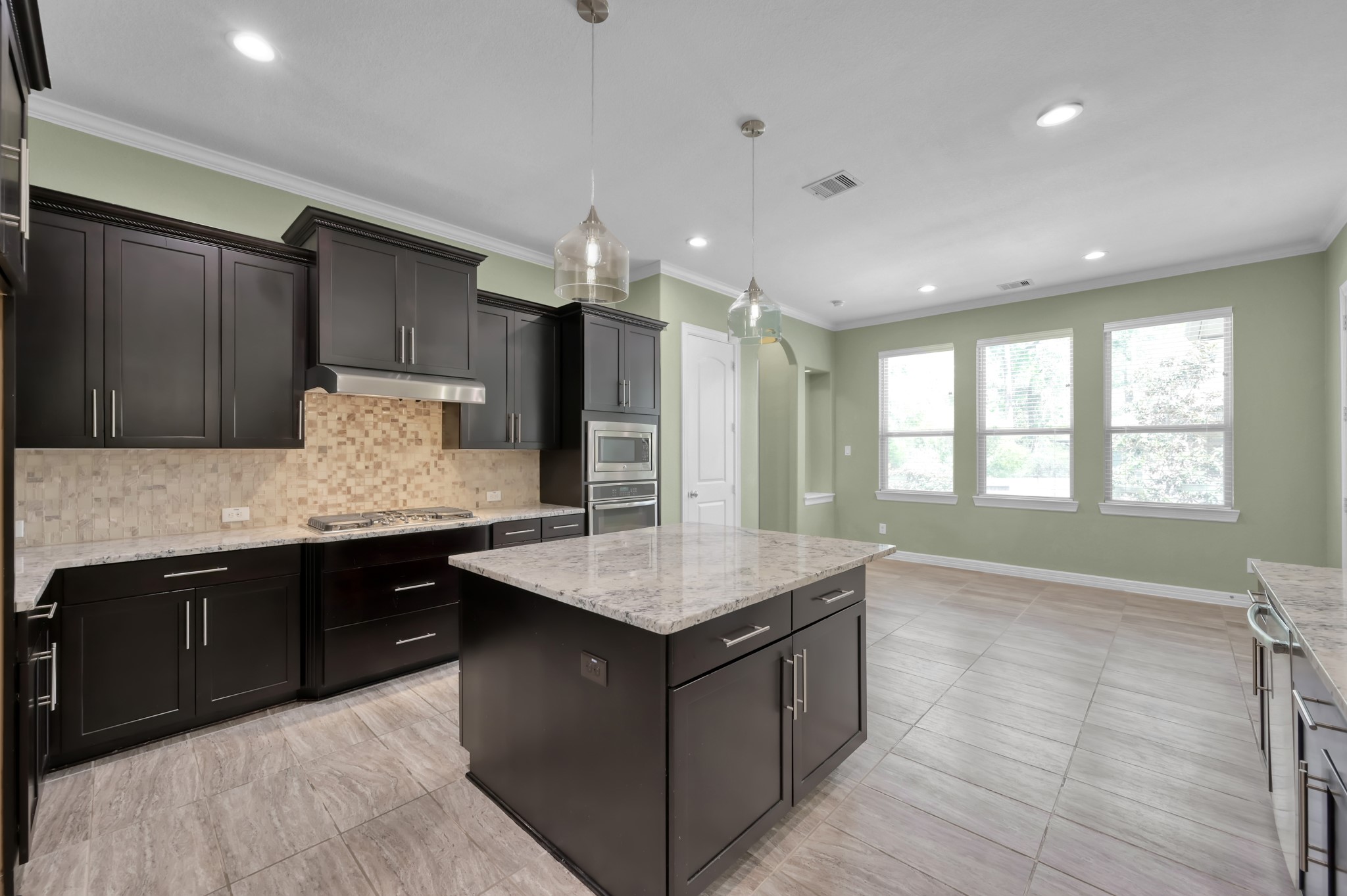23219 Belted Kingfisher Trail Spring, TX 77389 - Photo 10 of 43 a kitchen with kitchen island granite countertop a sink counter top space cabinets and stainless steel appliances