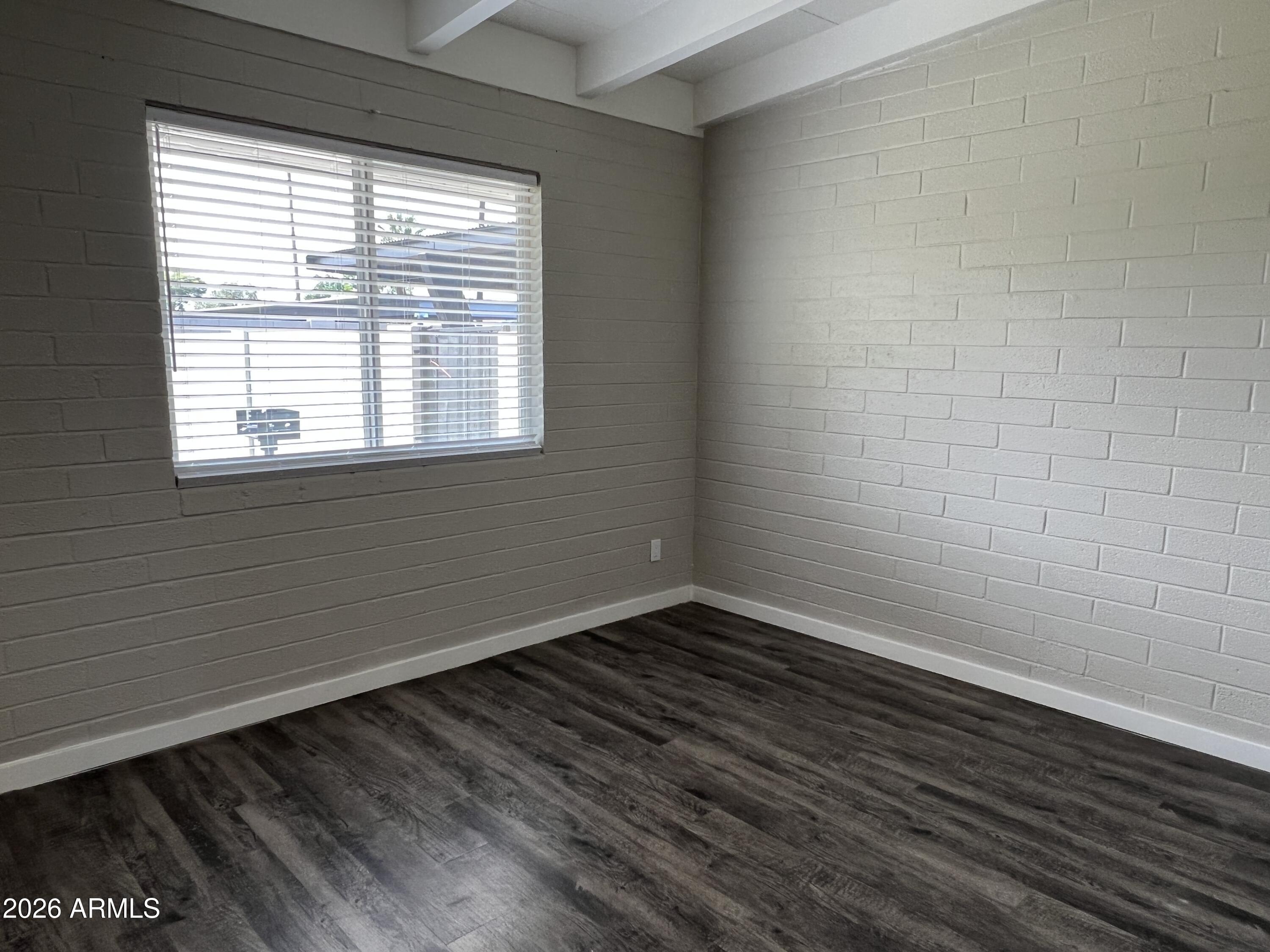 3630 North 15th Avenue Phoenix, AZ 85015 - Photo 11 of 12 a view of an empty room with wooden floor and a window