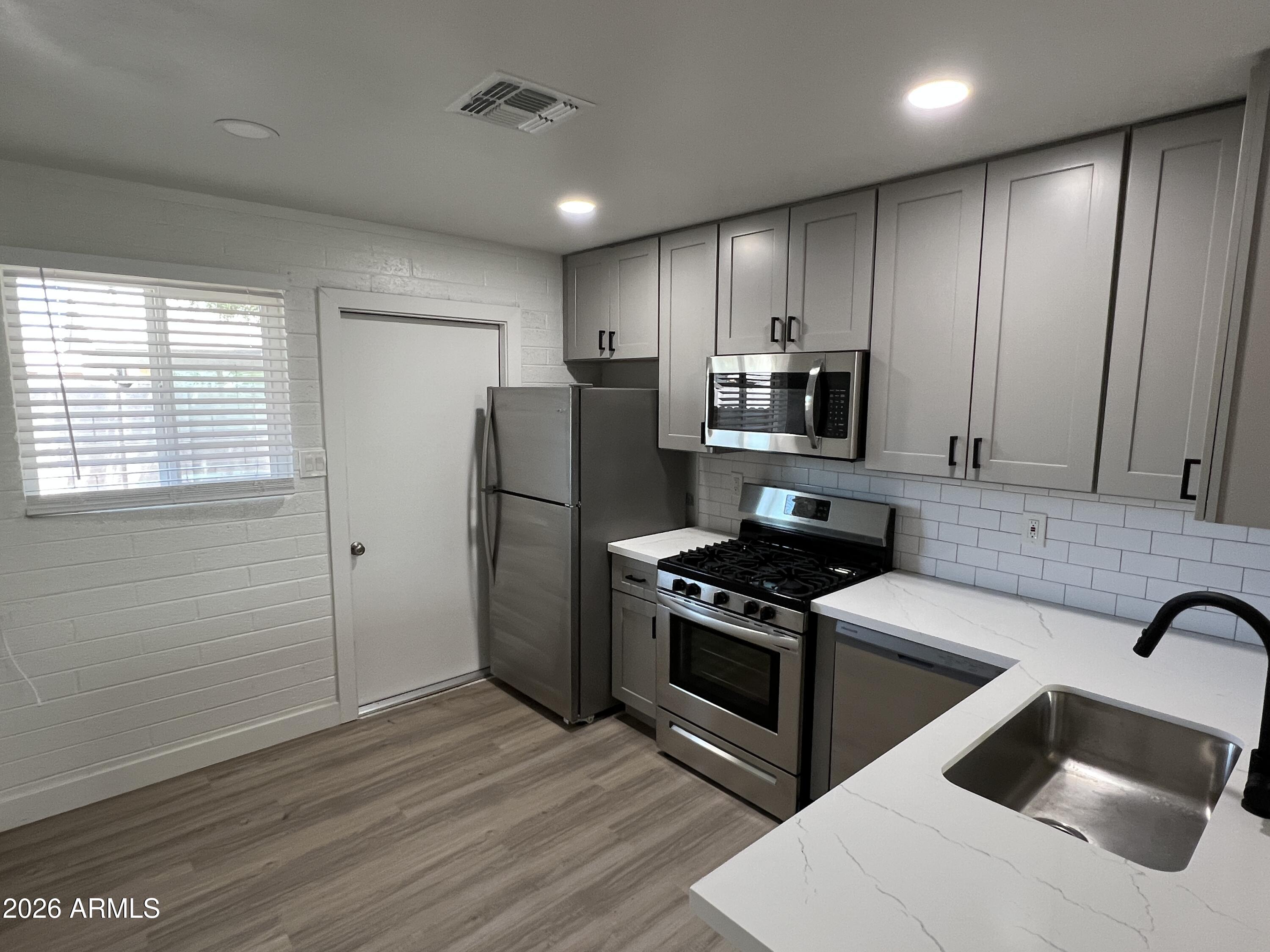 3630 North 15th Avenue Phoenix, AZ 85015 - Photo 4 of 12 a kitchen with stainless steel appliances granite countertop a refrigerator sink and stove