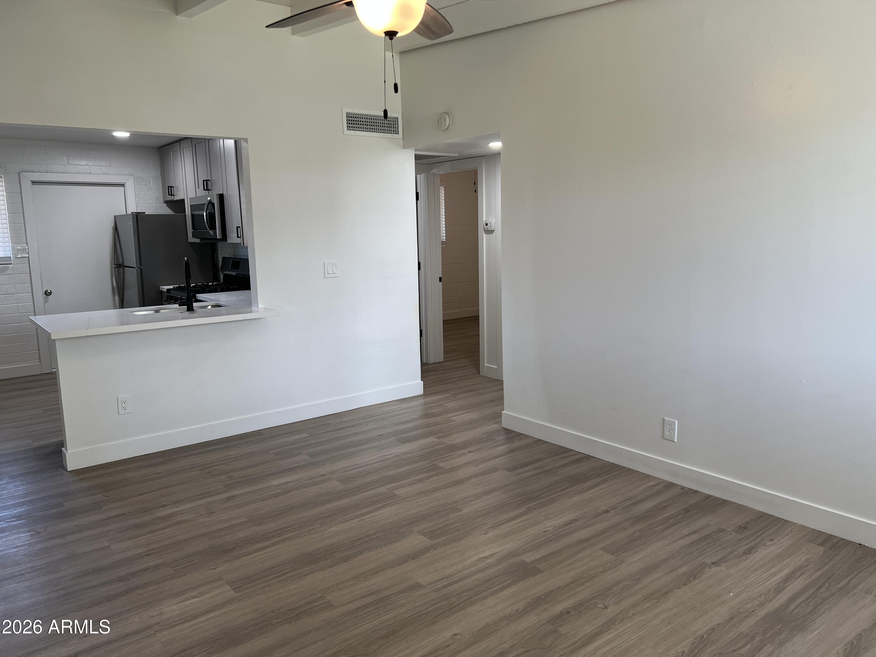 3630 North 15th Avenue Phoenix, AZ 85015 - Photo 5 of 12 a view of a kitchen with wooden floor and a refrigerator