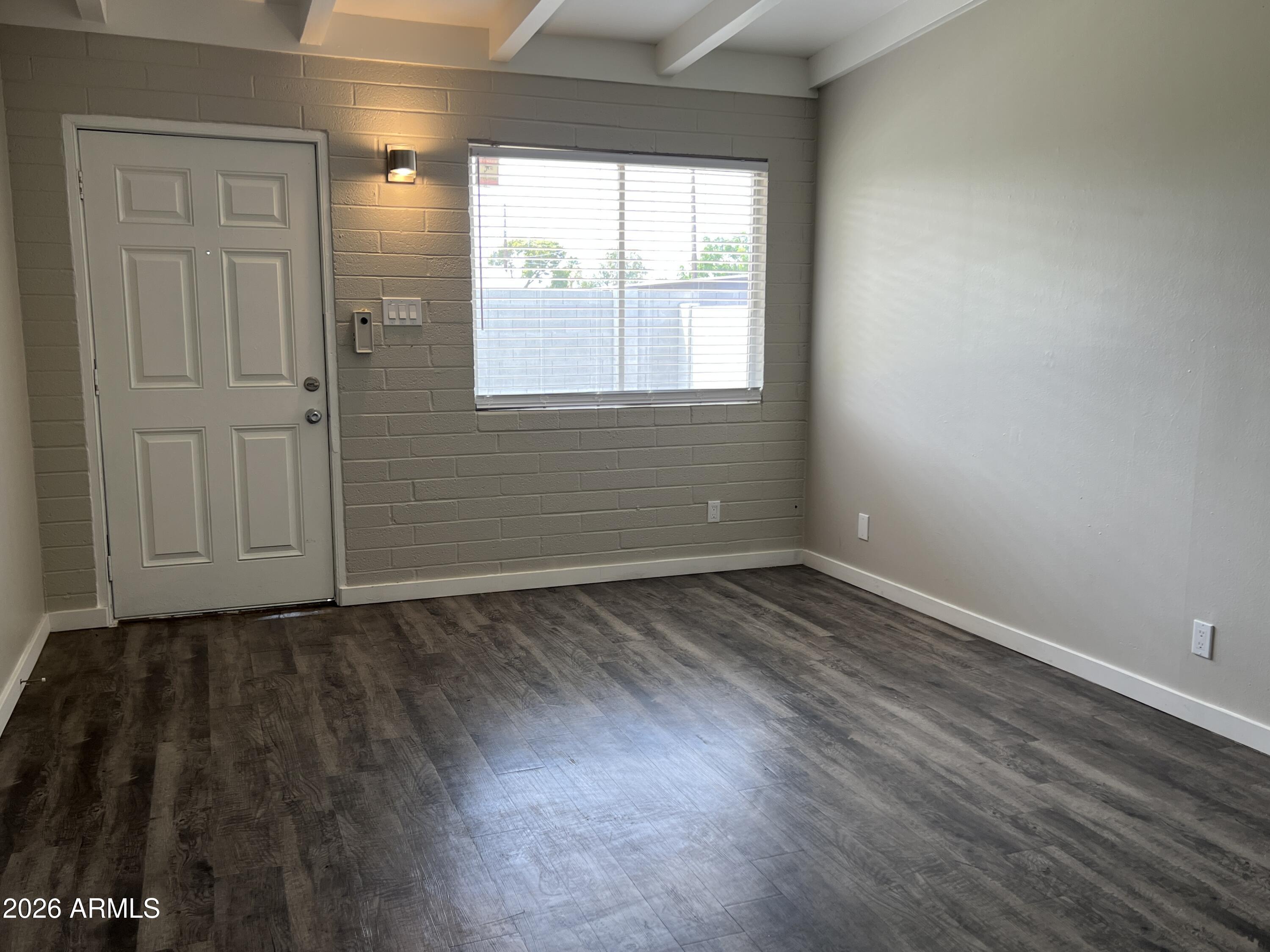 3630 North 15th Avenue Phoenix, AZ 85015 - Photo 9 of 12 an empty room with wooden floor and windows