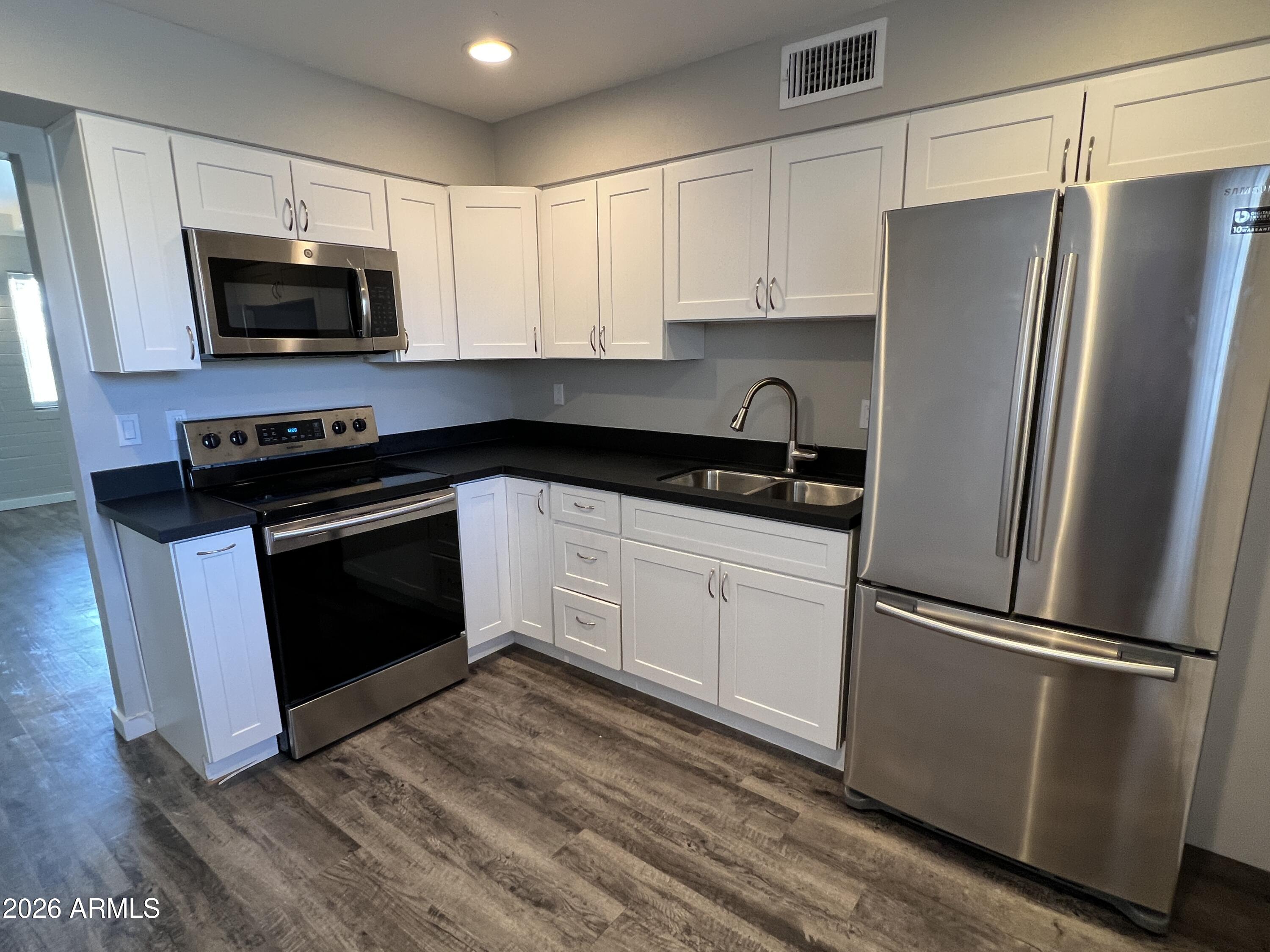 3630 North 15th Avenue Phoenix, AZ 85015 - Photo 10 of 12 a kitchen with a refrigerator stove and microwave