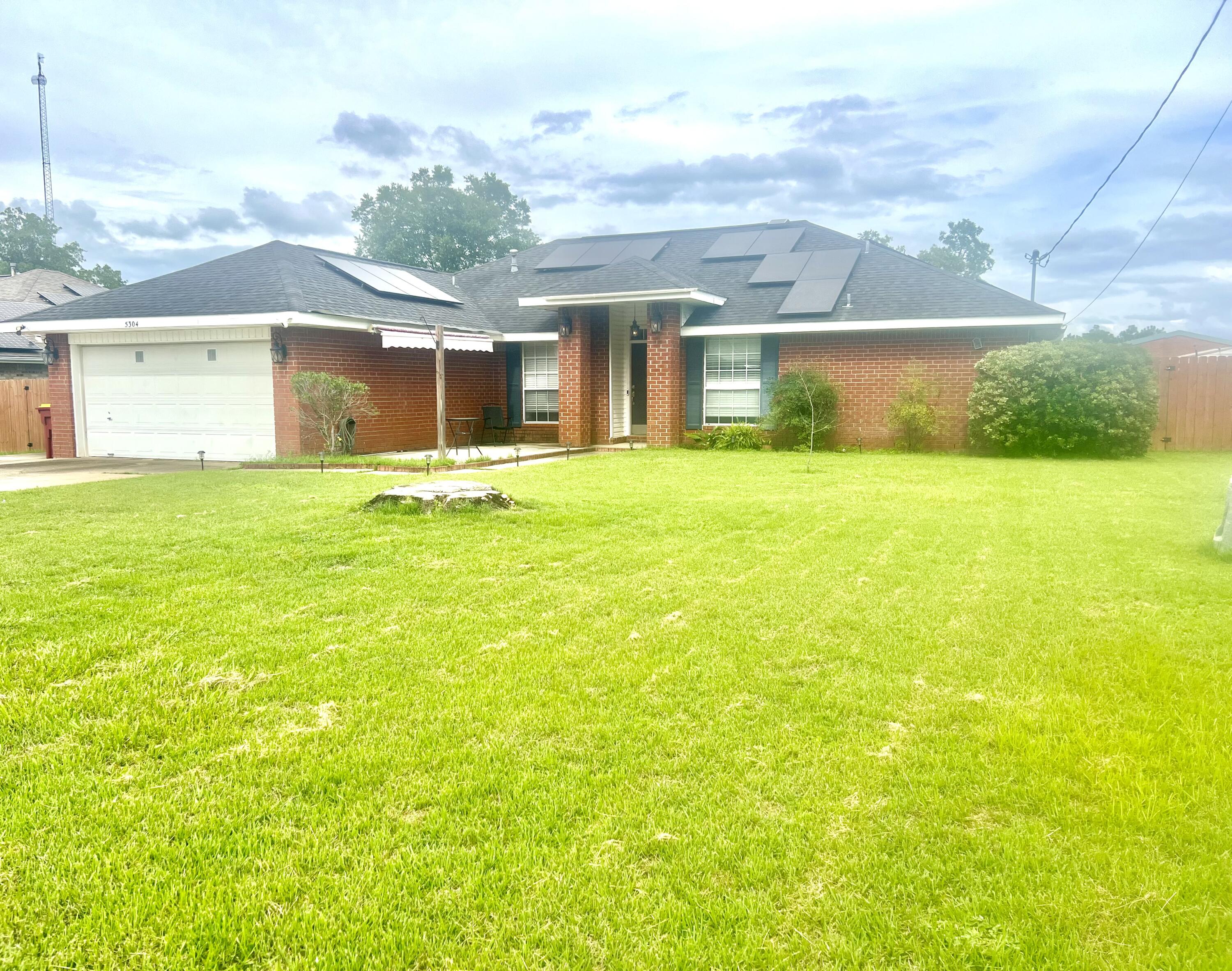 a view of a house with a yard and a garage