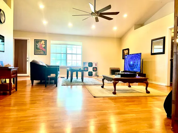 a living room with furniture and a table with wooden floor