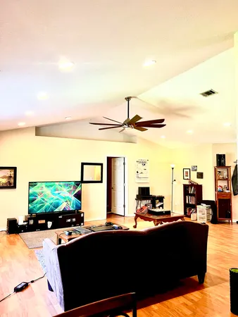 a living room with couches a flat screen tv and outdoor view