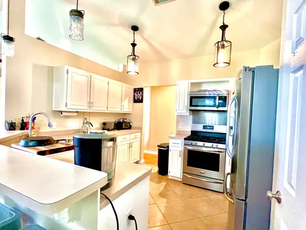 a kitchen with stainless steel appliances granite countertop a stove refrigerator and a sink with granite countertops