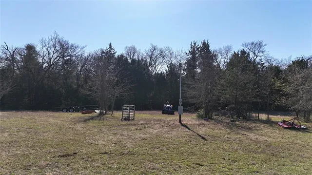 a view of a field with trees in the background