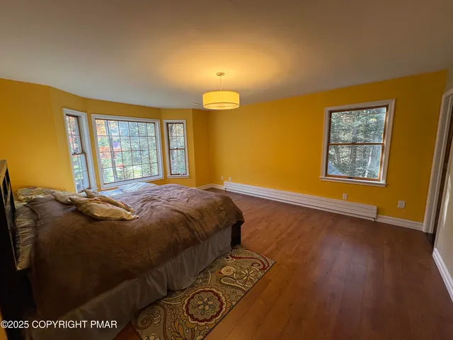 a bed sitting in a spacious bedroom next to a window