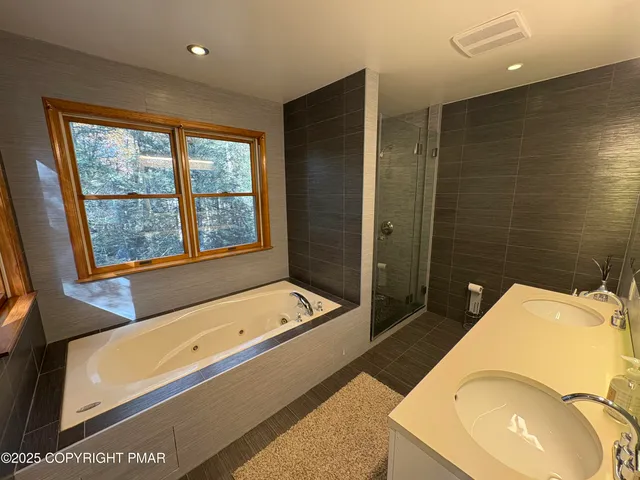 a bathroom with a tub sink and mirror