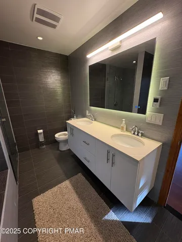 a bathroom with a double vanity sink and a mirror