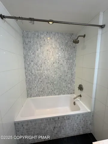 a bathroom with a bathtub and shower