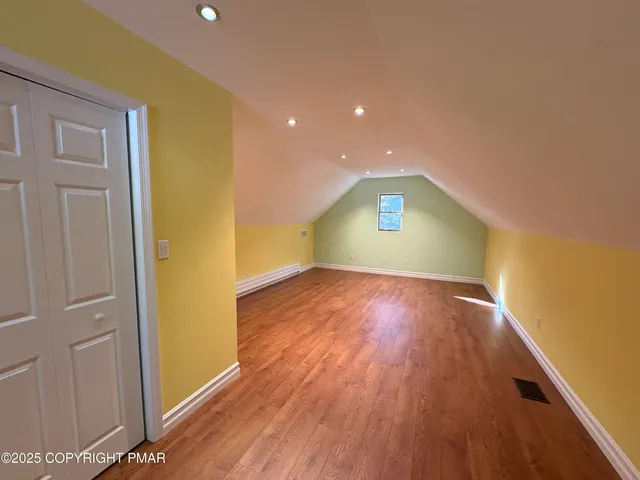 a view of an empty room with wooden floor
