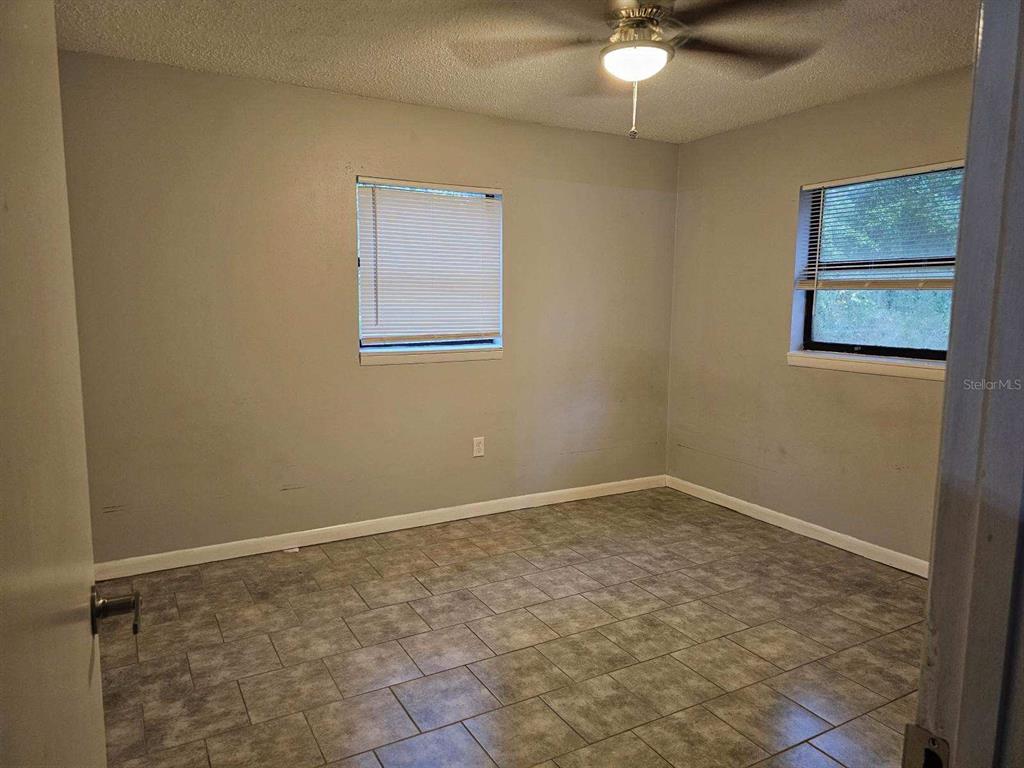112 Jasper Street Bushnell, FL 33513 - Photo 8 of 12 an empty room with a fan & a ceiling fan
