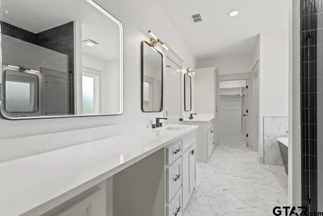 a bathroom with a double vanity sink mirror and