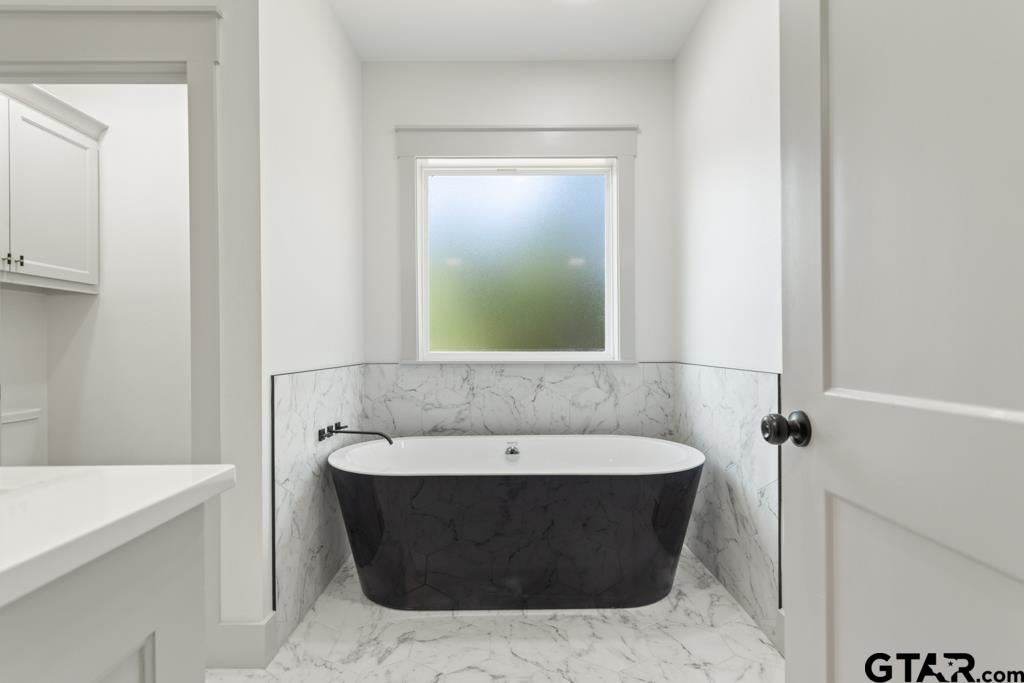 15837 Stillwaters Lindale, TX 75771 - Photo 15 of 34 a bathroom with a bathtub and a sink