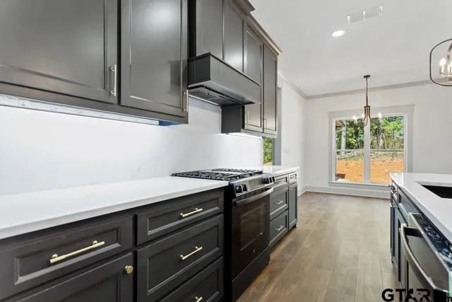 a kitchen with stainless steel appliances granite countertop a stove and a wooden cabinets