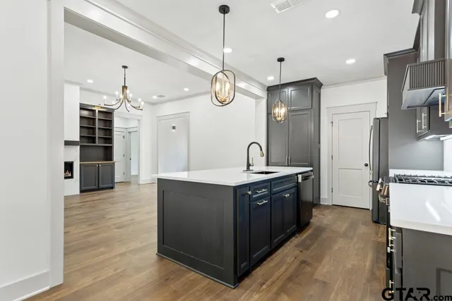 a large kitchen with stainless steel appliances granite countertop a stove and a refrigerator