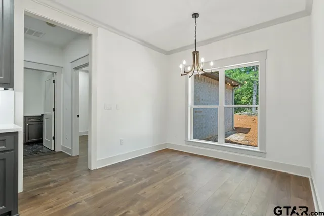 an empty room with wooden floor wooden floor and windows