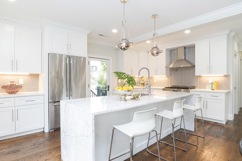 19 Verndale Street, Unit 2 Brookline, MA 02446 - Photo 3 of 8 a kitchen with stainless steel appliances granite countertop a sink a stove a refrigerator and island with wooden floor