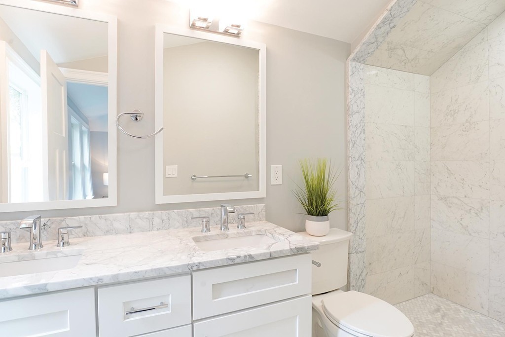 19 Verndale Street, Unit 2 Brookline, MA 02446 - Photo 7 of 8 a bathroom with a granite countertop toilet sink and mirror