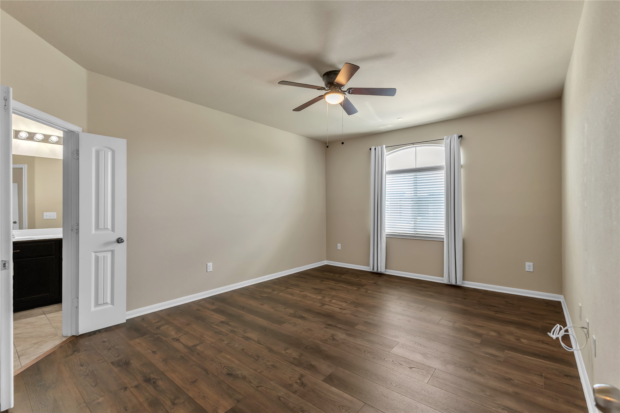 2880 Donnell Drive, Unit 2003 Round Rock, TX 78664 - Photo 18 of 31 Spacious room featuring wood-finish flooring, vaulted ceiling, and an arched window with blinds