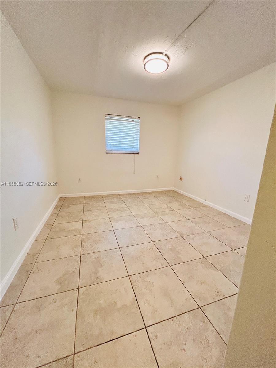 8603 Southwest 68th Court, Unit 22 Miami, FL 33156 - Photo 19 of 49 an empty room with white walls and tiles