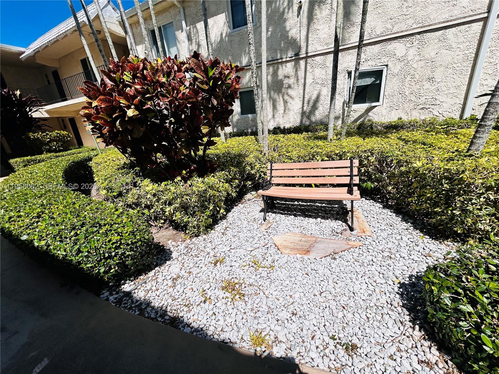 8603 Southwest 68th Court, Unit 22 Miami, FL 33156 - Photo 30 of 49 a wooden bench sitting in front of a building