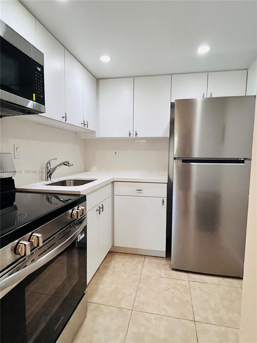 8603 Southwest 68th Court, Unit 22 Miami, FL 33156 - Photo 3 of 49 a kitchen with a refrigerator and a stove top oven