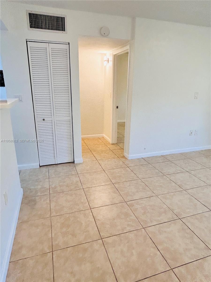 8603 Southwest 68th Court, Unit 22 Miami, FL 33156 - Photo 7 of 49 an empty room with a bench and cabinet in it