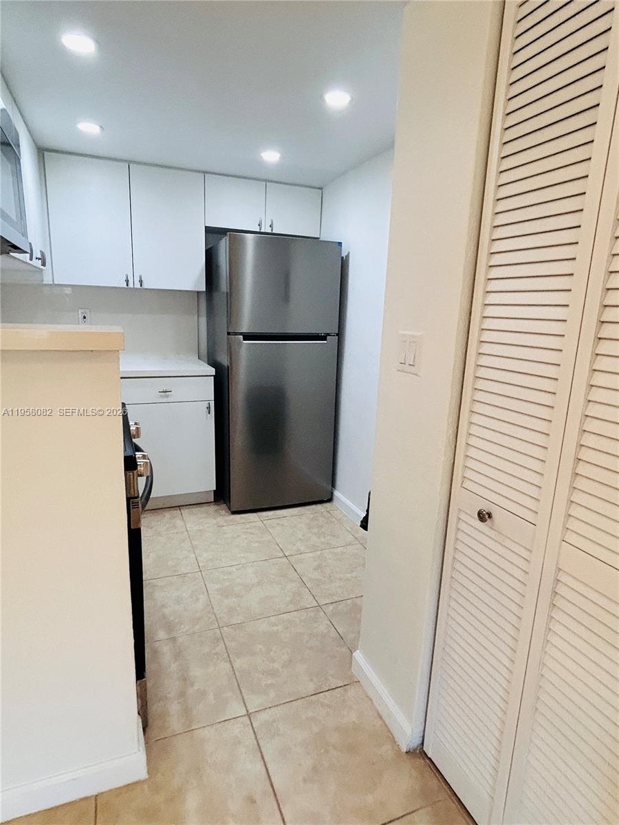 8603 Southwest 68th Court, Unit 22 Miami, FL 33156 - Photo 9 of 49 a kitchen with a refrigerator a sink and cabinets